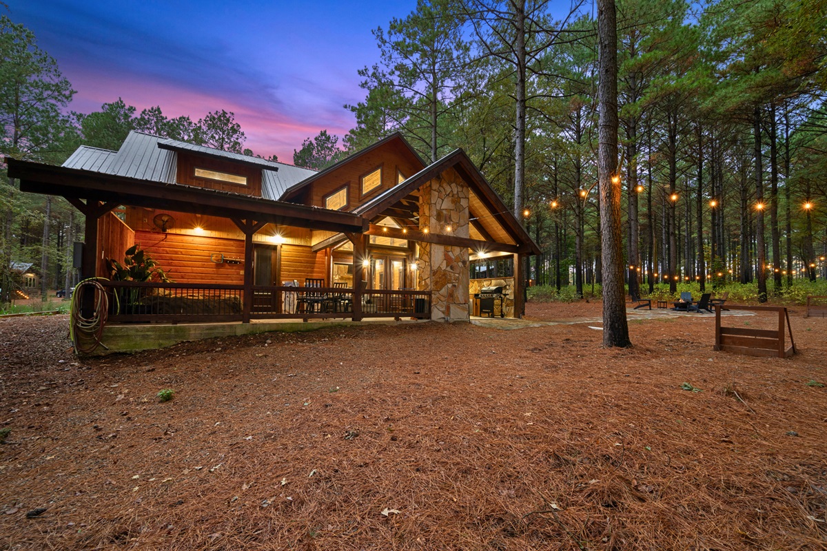 Side exterior view with warm lighting and forest backdrop.