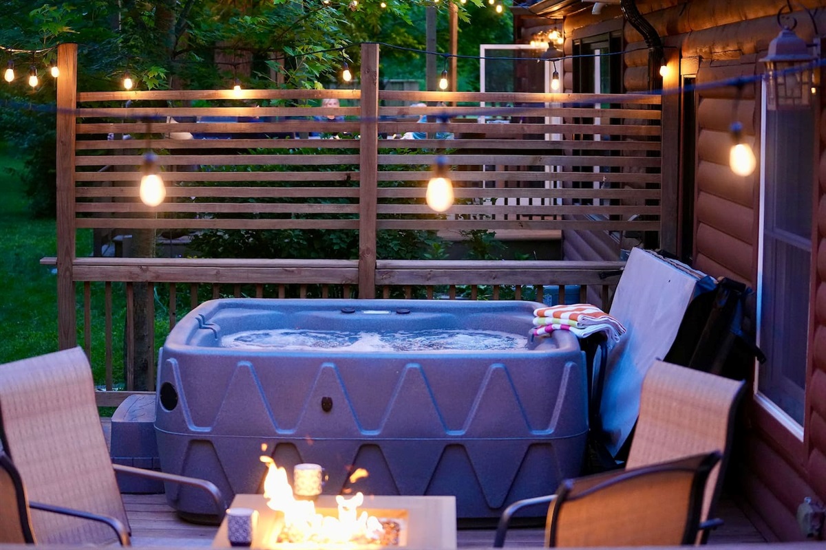 The fire and cafe lights provide a warm inviting atmosphere to this deck.