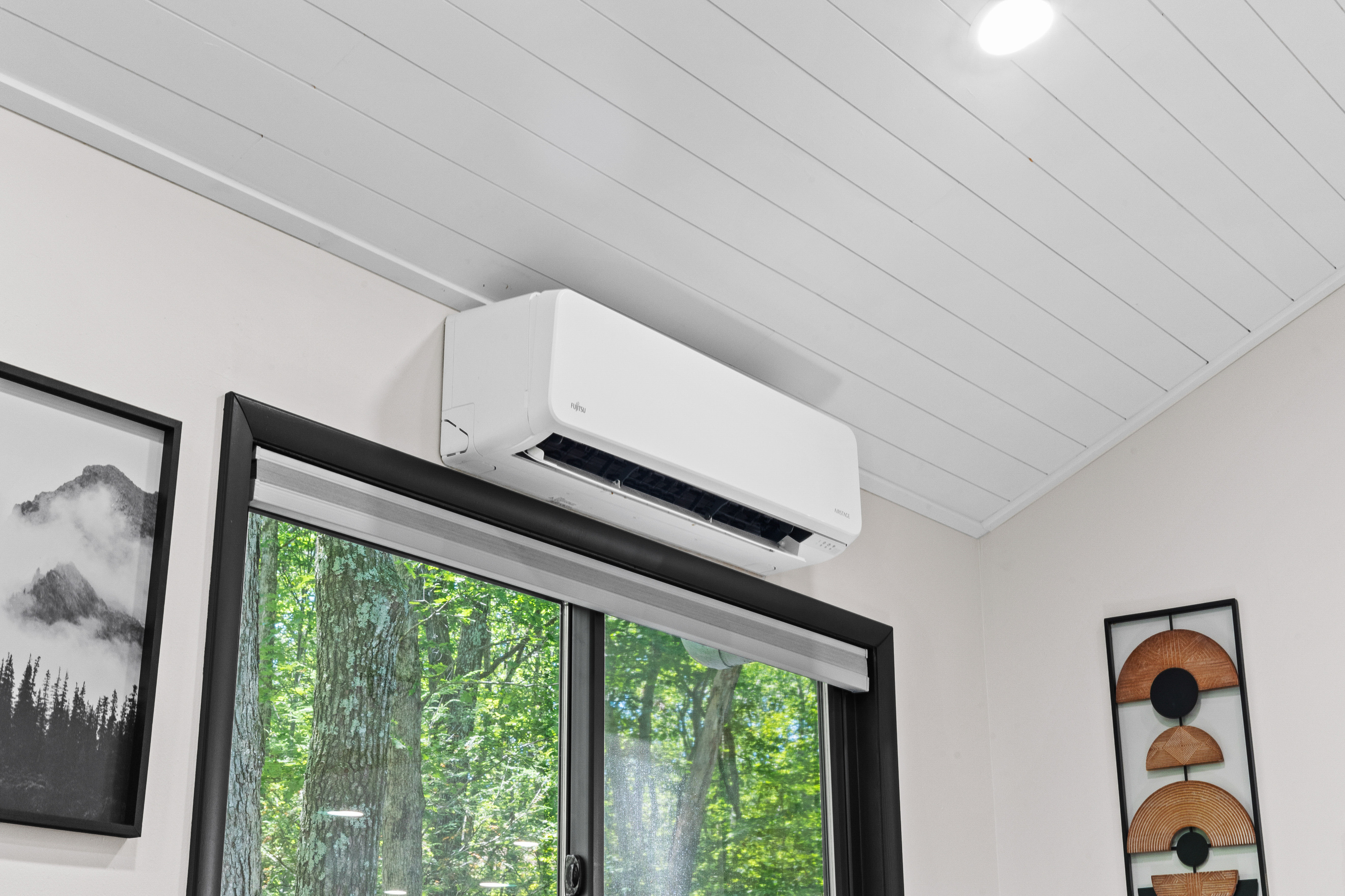 The home features modern mini-split heating and cooling units throughout with handheld remote controls