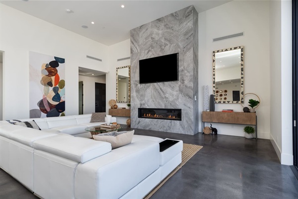 Living Area with fireplace, large Smart TV and leather sectional with reclining headrests and seats