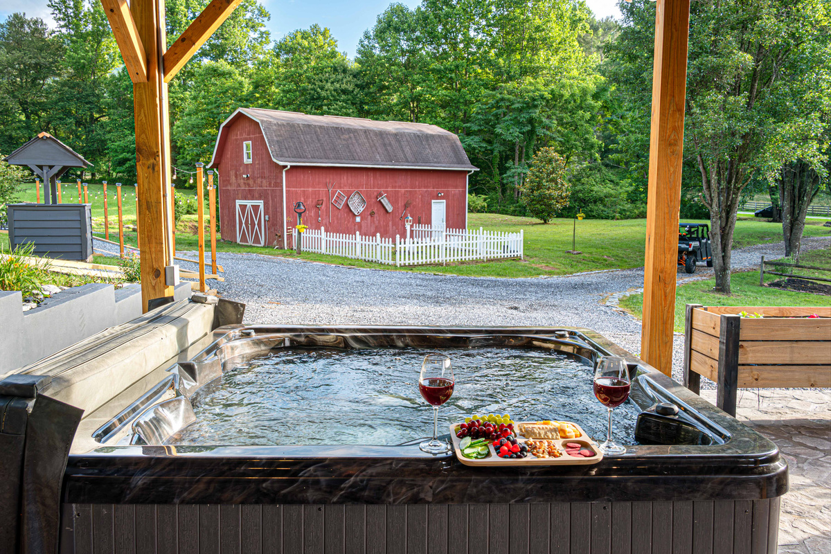 Hot Tub Oasis: Unwind in the bubbling warmth with stunning views of nature and red barn charm!