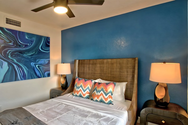 Spacious 2nd bedroom with queen size bed and vivid blue accent wall