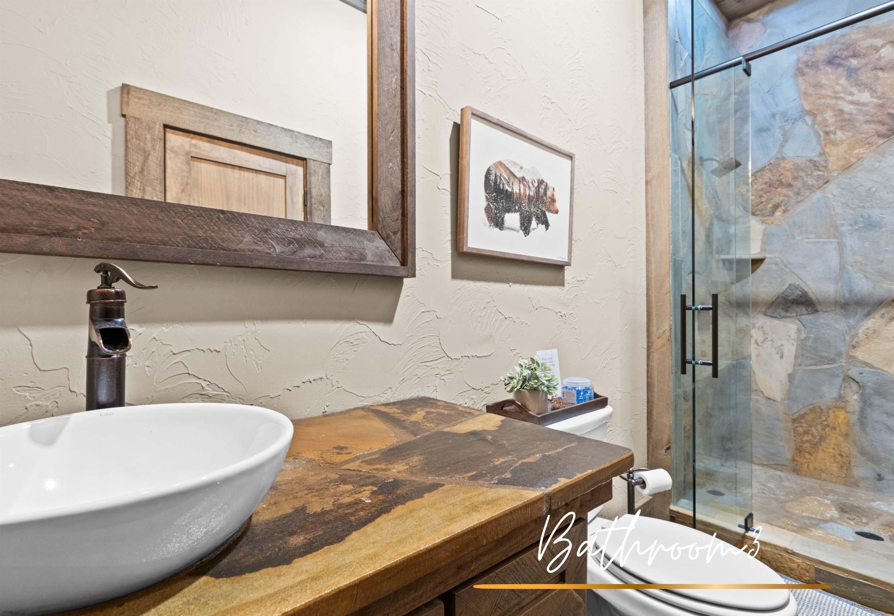 Bathroom 3: features natural stone details, sleek fixtures, and a glass-enclosed shower for added elegance.