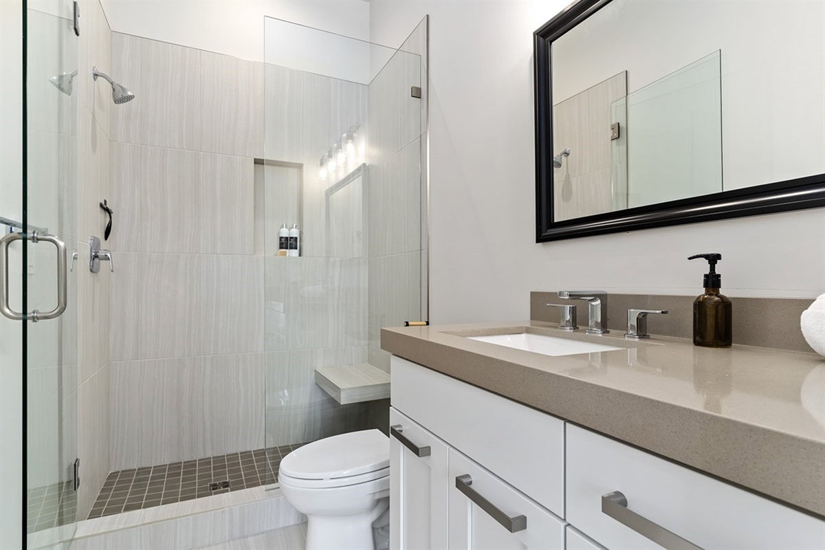 A modern bathroom with clean finishes and a walk-in shower.