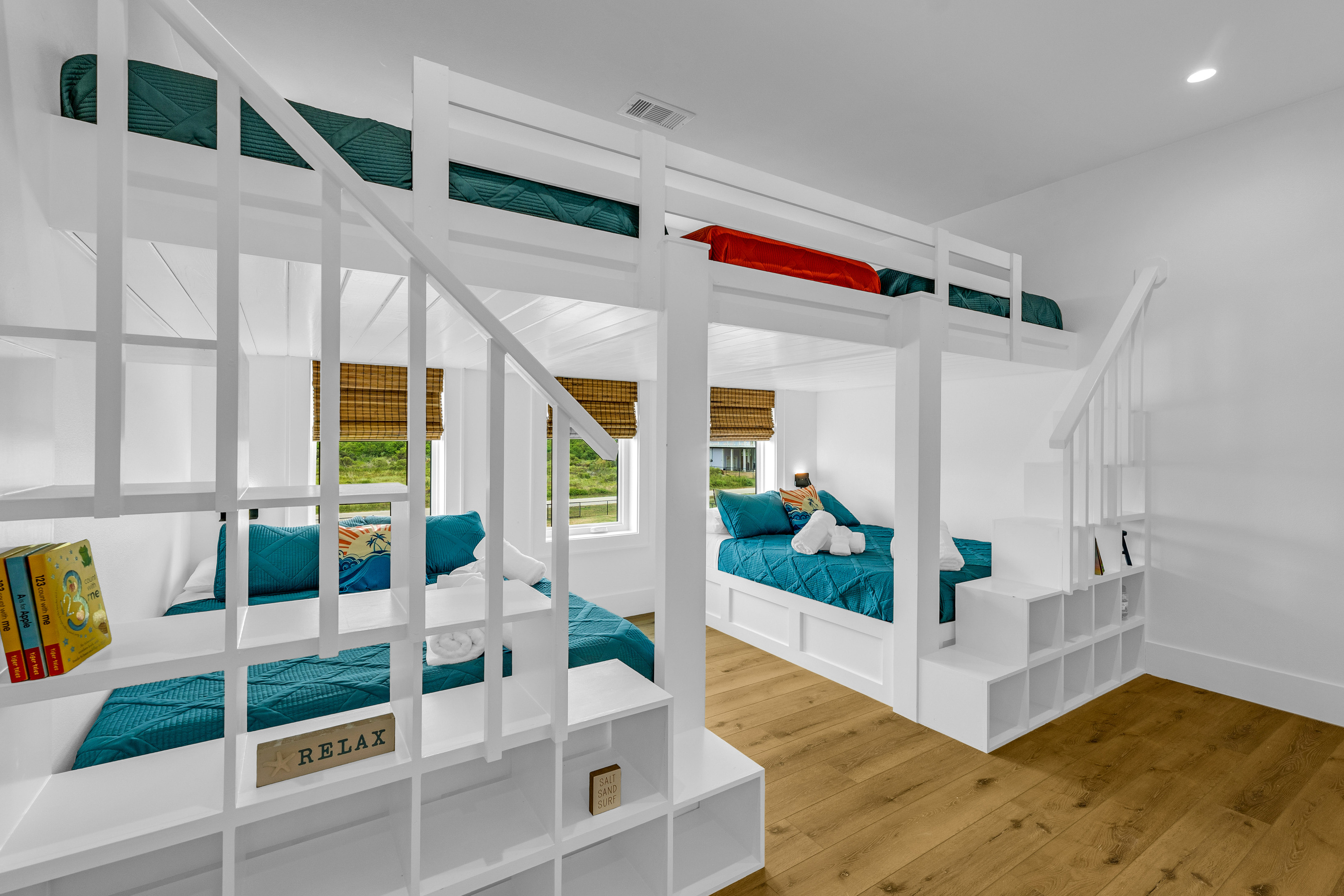 Cair Paravel: Custom bunks with private staircases make this bunk room a favorite with kids and kids-at-heart, all finished in crisp white shiplap.