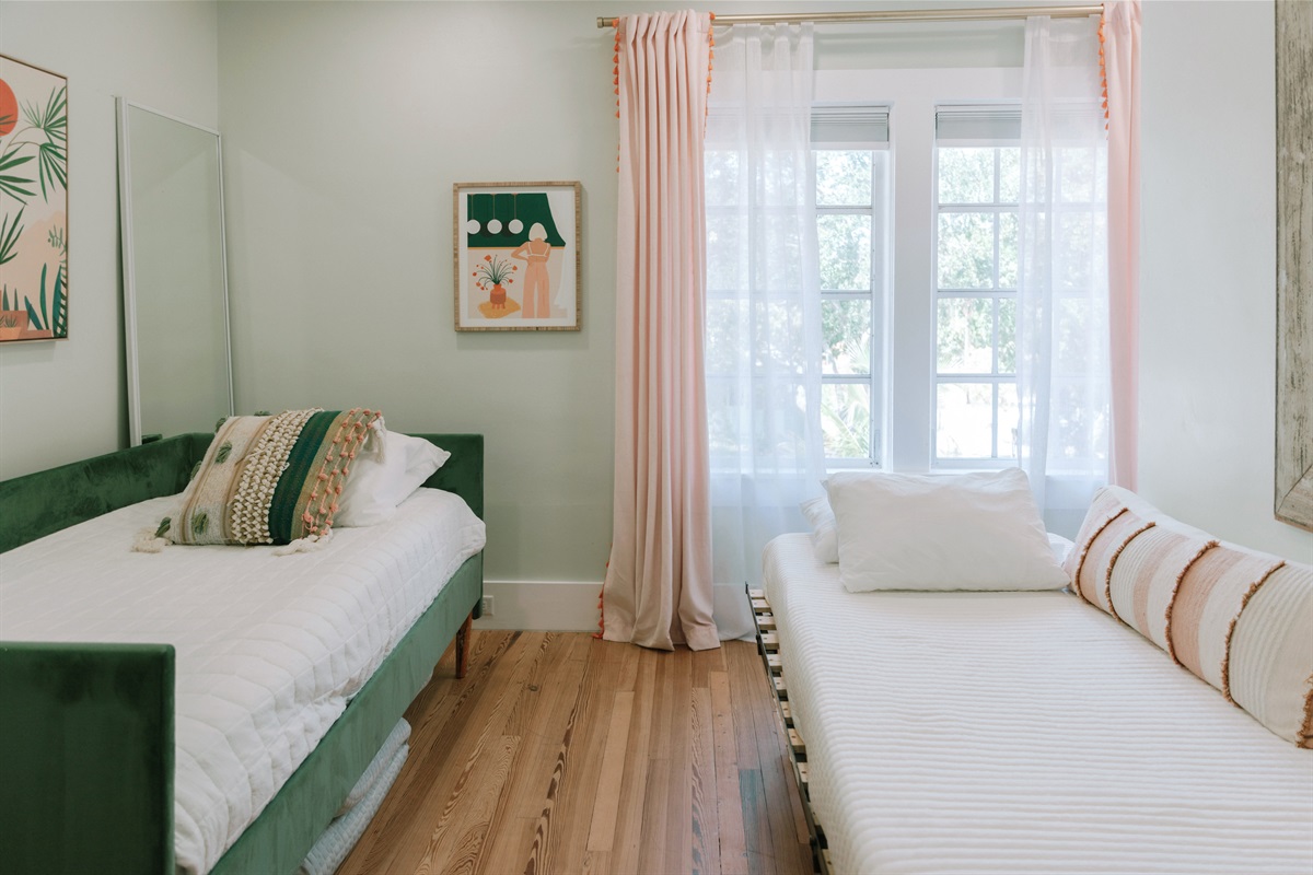 The third bedroom has a daybed and a pullout bed, garnished with colorful art throughout.
