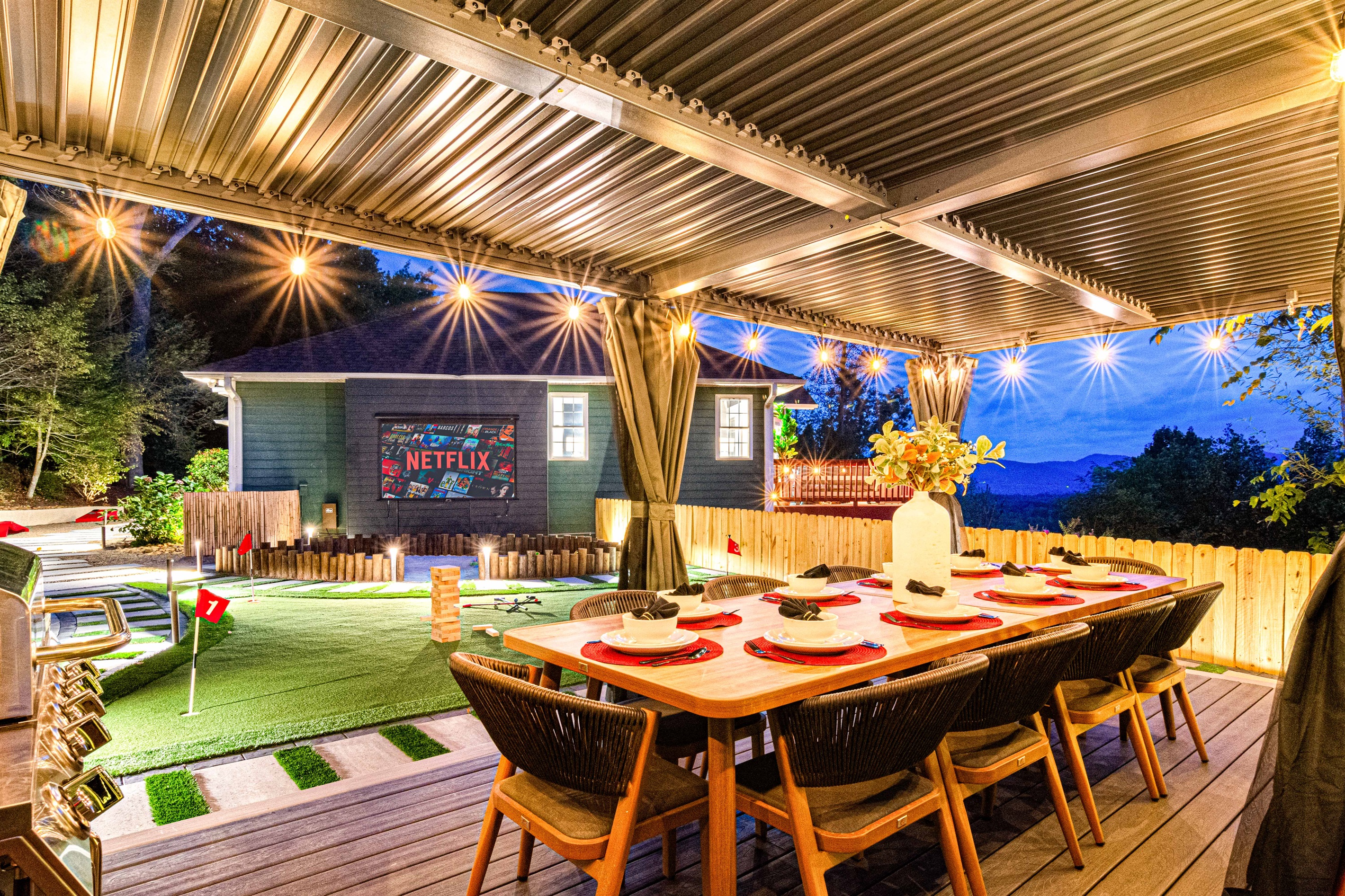 Enjoy an evening under the stars with alfresco dining, a cozy outdoor movie setup, and mini-golf—an inviting space for fun and relaxation with mountain views in the background.