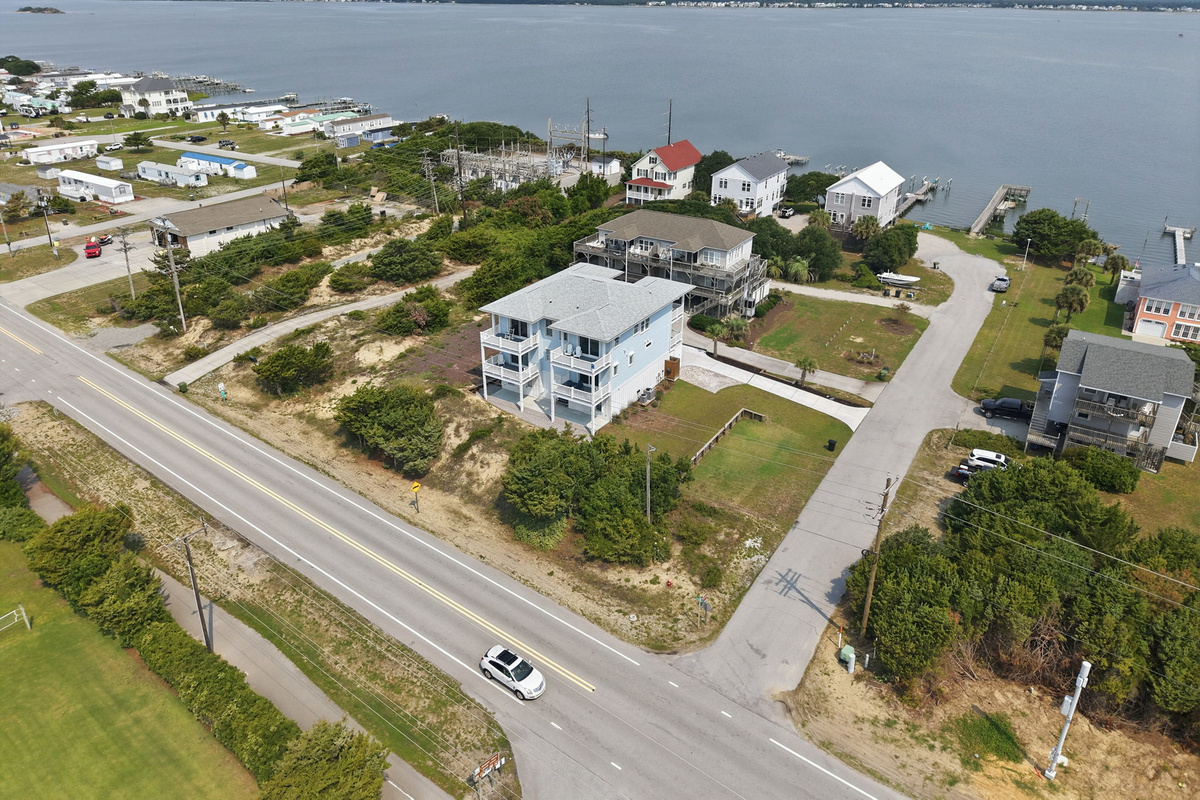 Elevated drone perspective highlighting the home&rsquo;s spacious lot, surrounding coastal neighborhood, and water views