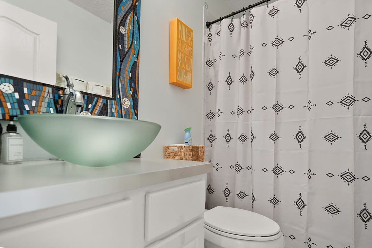 The second-floor guest bathroom sits off the main hallway, with a shower and tub combination. Bright, simple, and shared between the two bedrooms that do not happen to have a bathroom of their very own.
