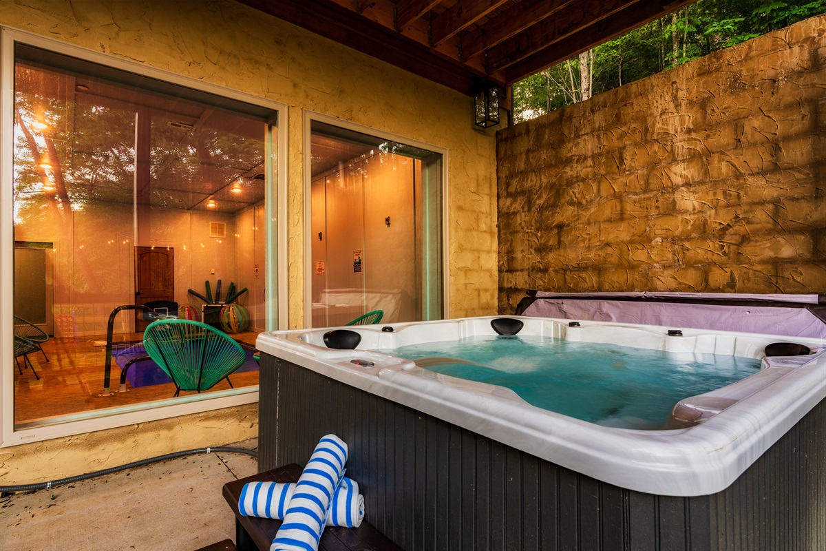 Hot tub on lower deck with pool room in the background