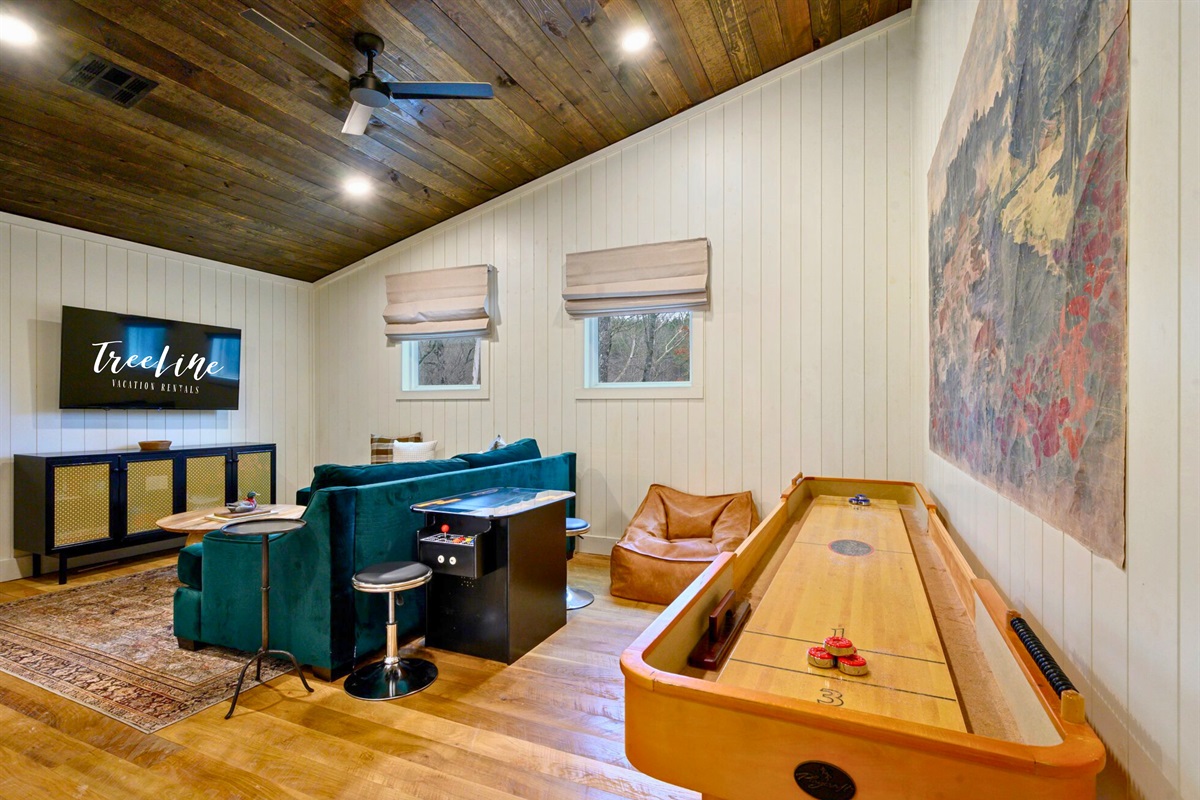 The game room brings the fun with cozy seating, a shuffleboard table, and plenty of space to unwind between adventures.