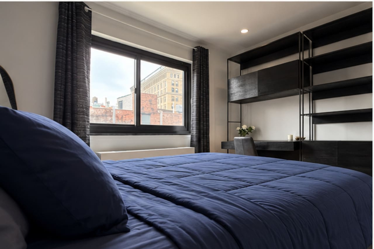 Bedroom with stunning New York City skyline views — wake up to Lower Manhattan in our Little Italy 2-bedroom rental