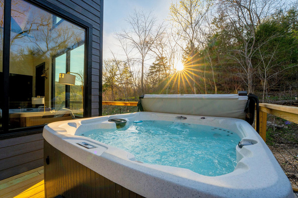 Soak under the trees and over the flowing creek in the hot tub perched on the private deck while the surrounding forest settles into evening