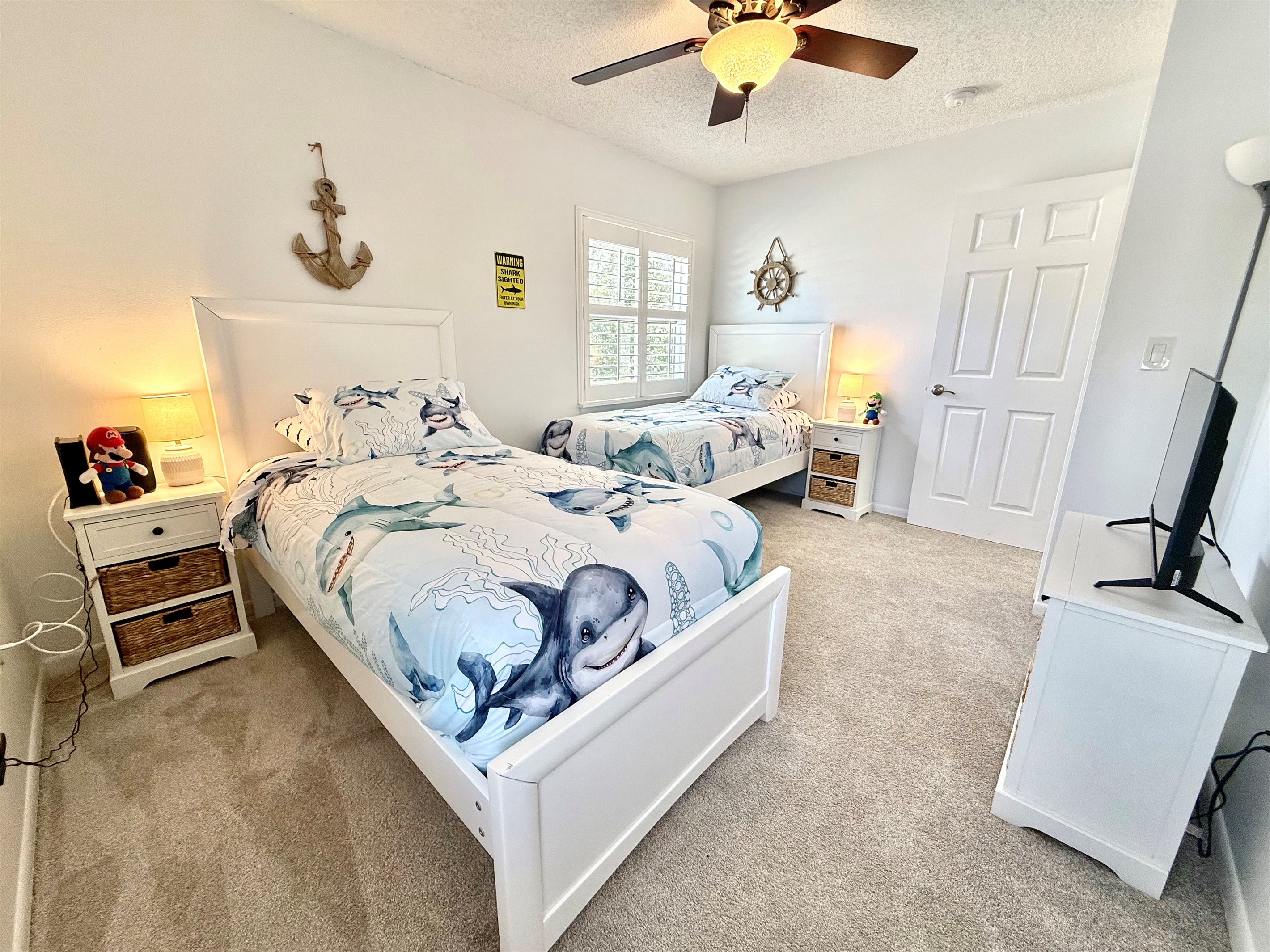 Fun and family-friendly room with two twin beds and playful shark-themed bedding.