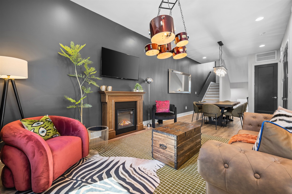 Living Room: Vibrant decor meets comfort with a stylish fireplace and eclectic seating for gatherings!