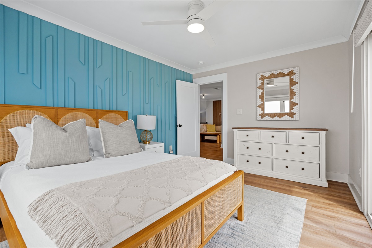Comfortable queen bedroom with modern furnishings, spacious layout, and private balcony access