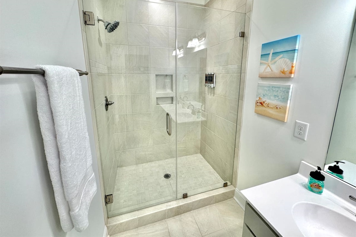 Primary bathroom features a walk-in shower, double sinks and a toilet room.