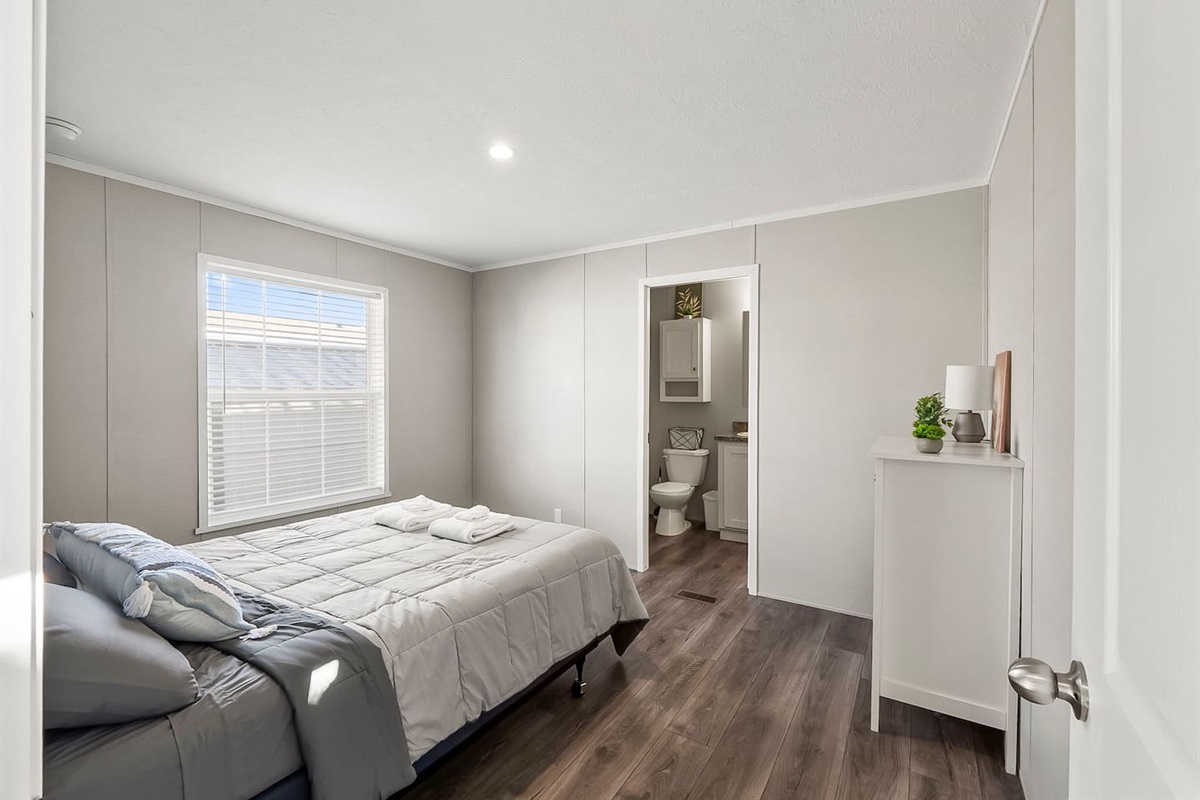 Spacious bedroom with a queen bed, natural light, and direct access to an ensuite bathroom for added convenience.