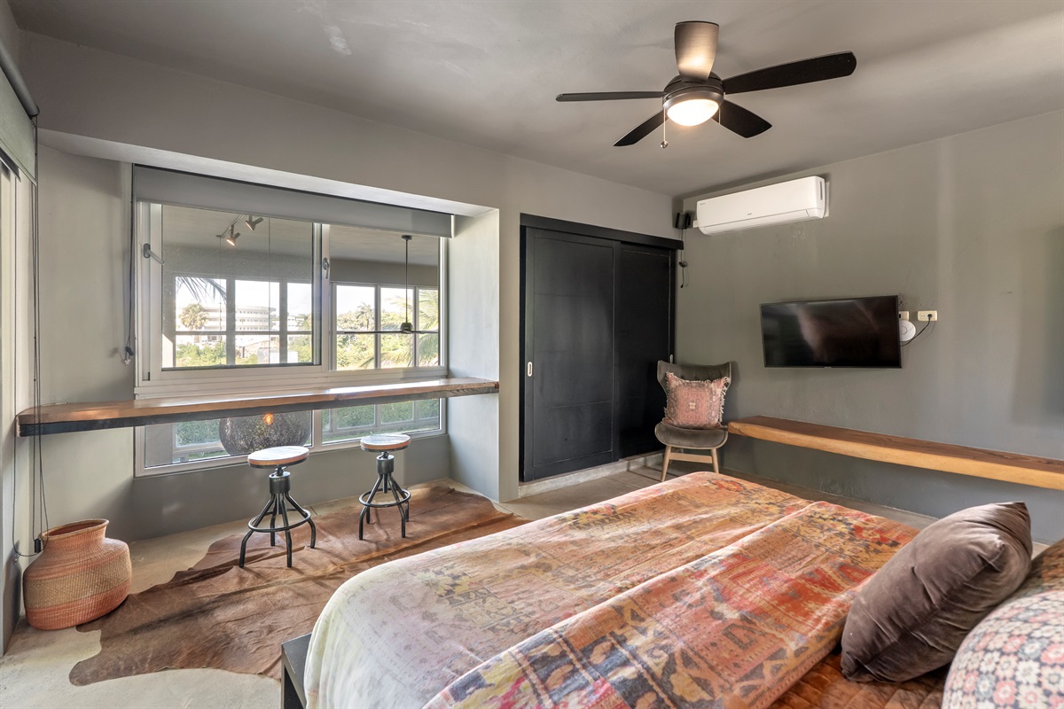 Spacious bedroom with a comfortable bed and large TV.