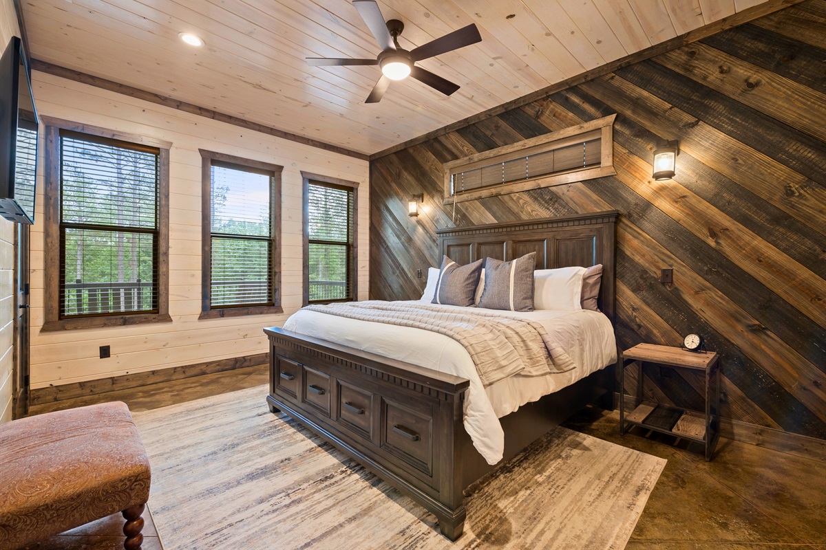 This bedroom shows spacious layout and abundance of natural light through large windows.