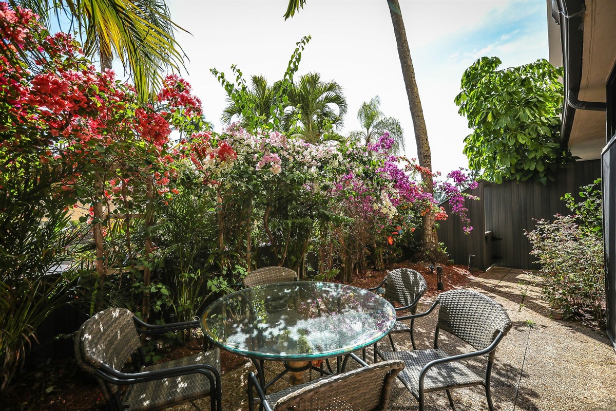 Private patio surrounded by lush tropical plants, your quiet morning coffee spot.