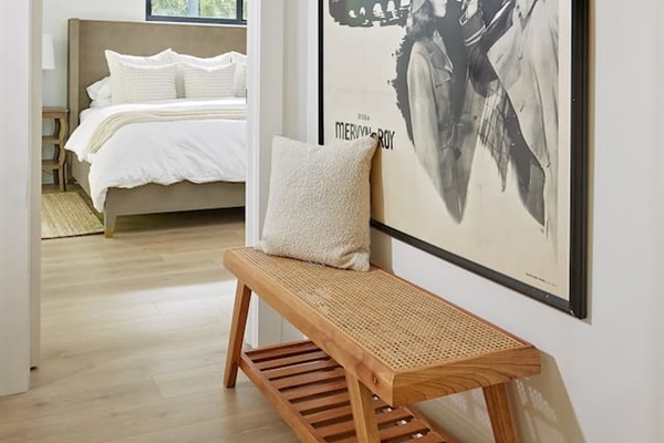 The hallway connecting the kitchen and living room to the first-floor king suite also includes a staircase on the left, leading to the second-floor king suite. On the way, you’ll find a convenient laundry area equipped with a Miele washer and dryer.
