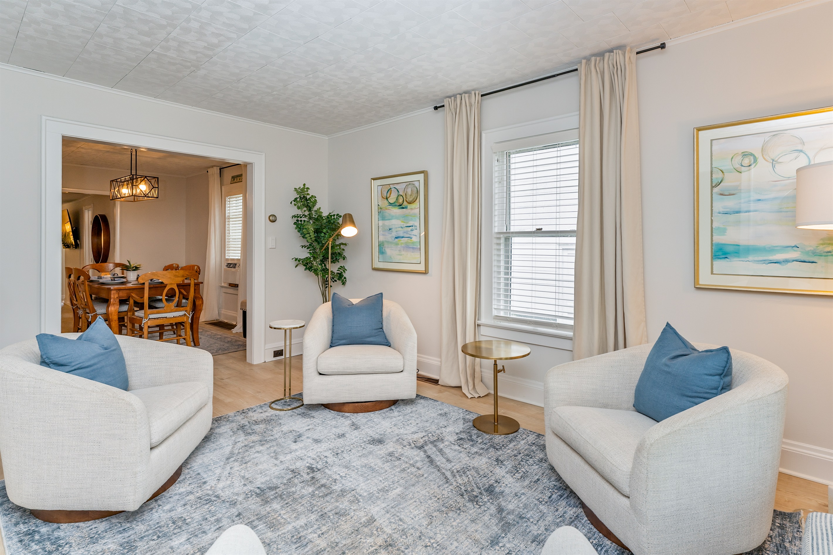 Bright and airy gameroom/ sitting space with plush seating, Mrs. Pac man game and and board games peeks-through to the elegant dining area—perfect for entertaining or relaxing.