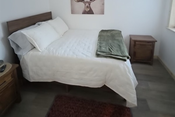 Bedroom on main floor includes a queen size bed, nightstand, closet and TV [Photo is representative but is not from this cabin].