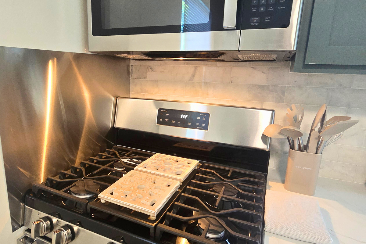 Five-burner gas range, stainless appliances, and everything you need to cook at home.