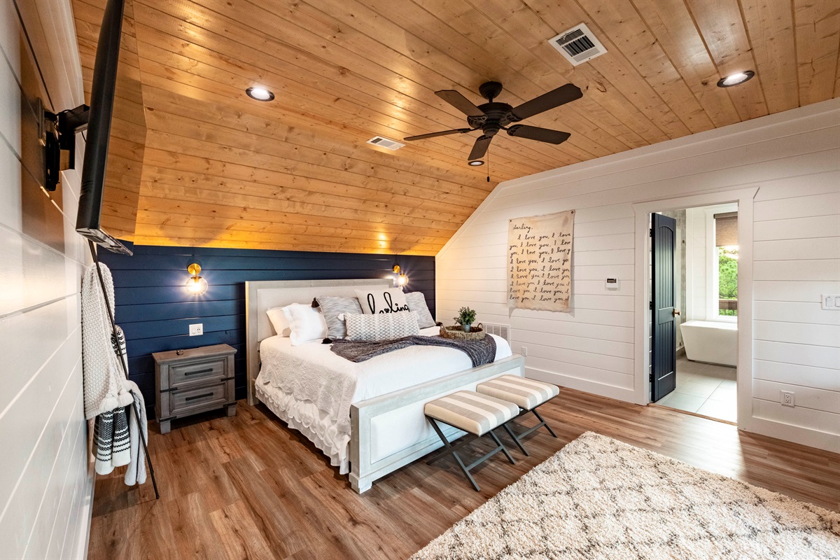 Cozy king bedroom with warm wood ceilings and peaceful cabin ambiance