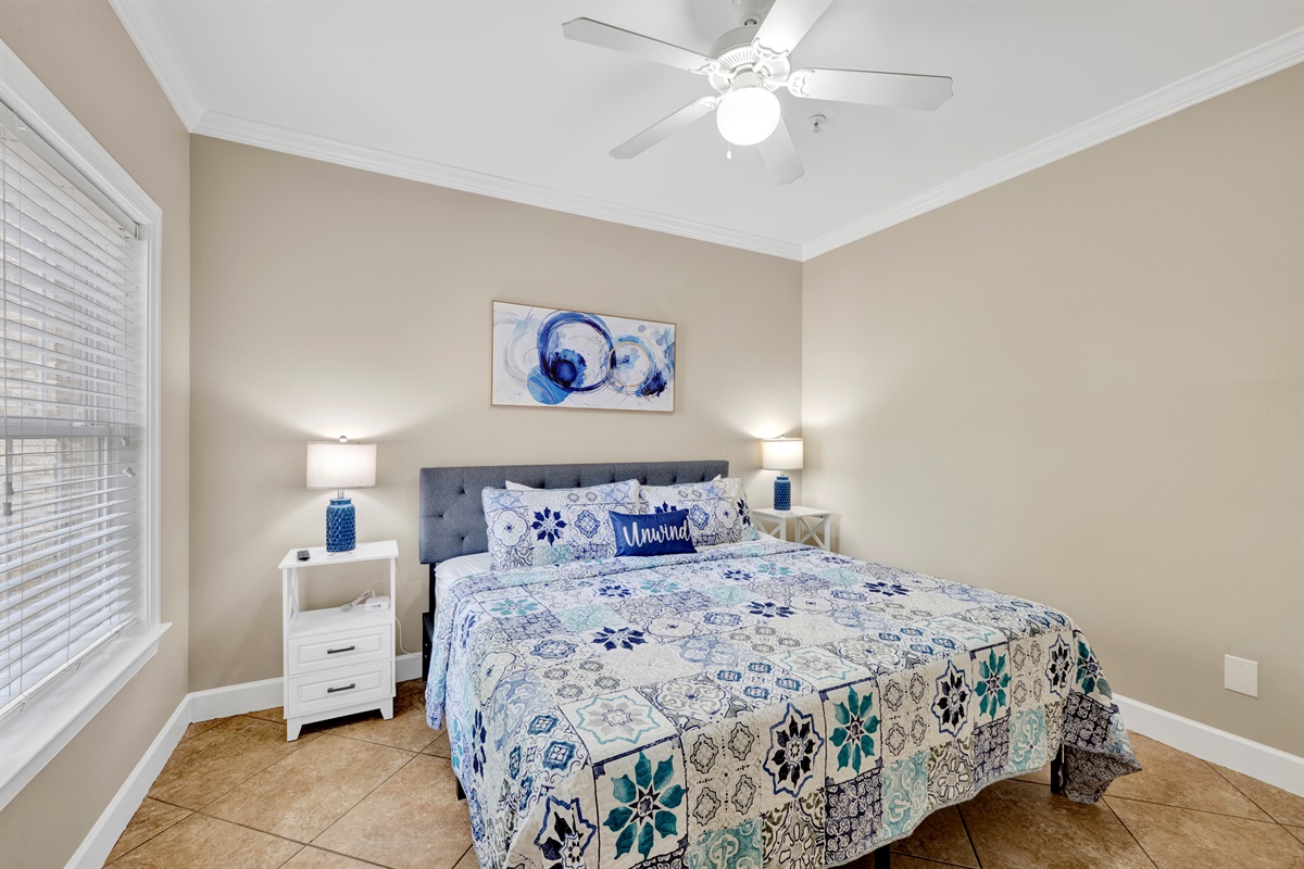 Bedroom 2 offers a king bed, ceiling fan and wall mounted smart tv 