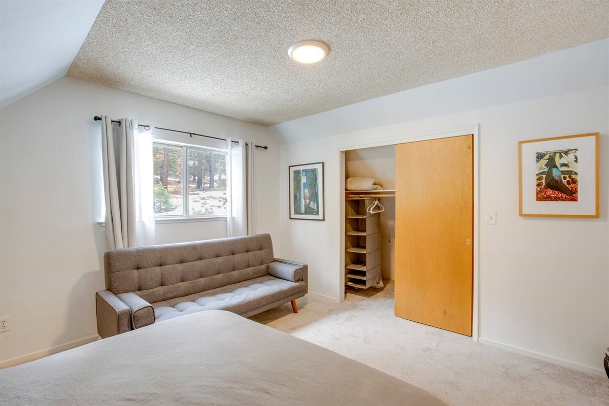 Upstairs bedroom with a futon and lots of storage space.