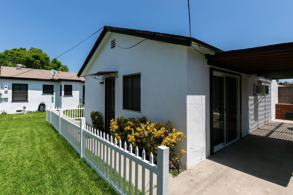 "Bonus room"/Studio, sliding doors and back patio with awning.  Backyard view toward main house.