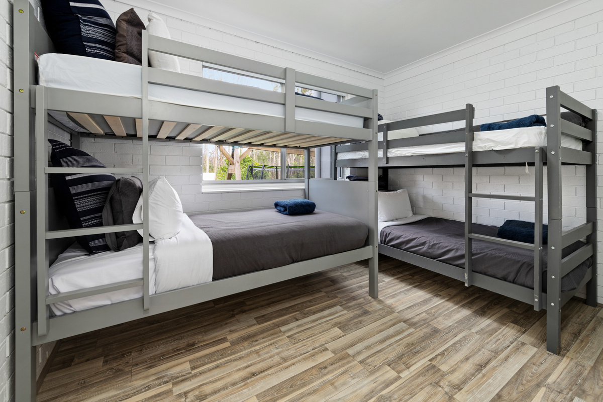 This downstairs bunk bedroom expands the two-level setup at Skye’s Beach House, adding a dedicated sleeping zone beside the lower living spaces.