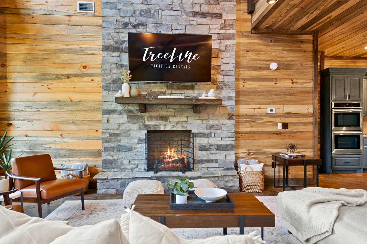 Cozy up in this inviting living area, where a warm fireplace takes center stage, enhanced by natural wood finishes