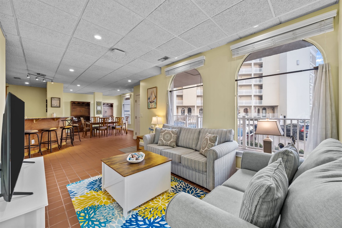 Open living space with arched windows, natural light, and clear sightlines into the dining area: perfect for gathering, entertaining, or keeping everyone connected in one easy-flow layout
