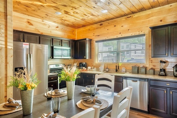 A chef's dream kitchen with top-of-the-line appliances, a generous dining table, and tasteful artwork.