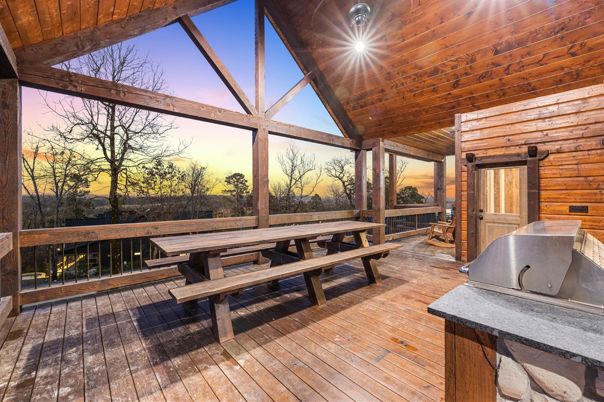 Spacious covered deck with picnic seating and beautiful forest surroundings