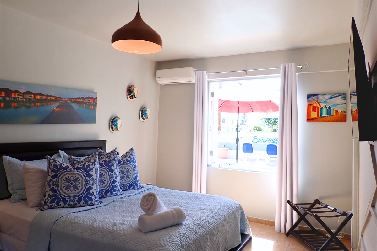Bedroom Retreat: Bright, stylish room with vibrant decor and lovely views of the outdoor patio!