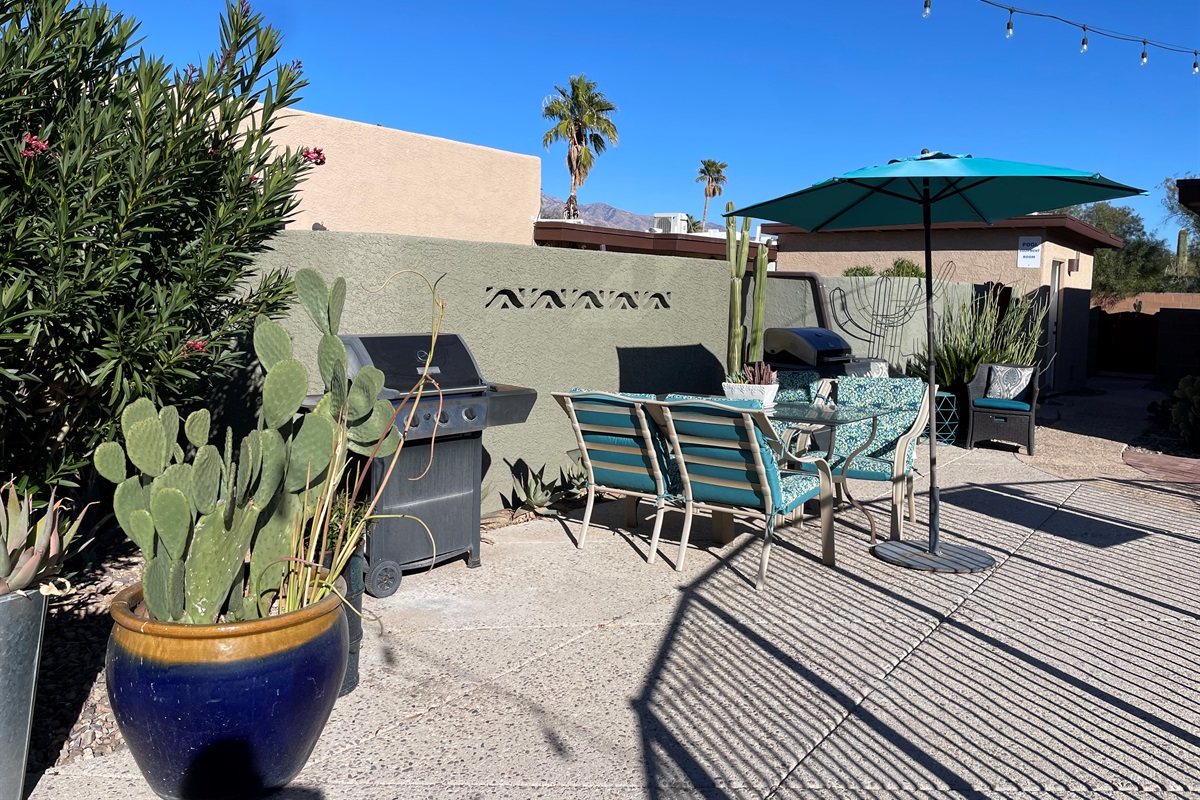 Outdoor dining near grills and pool.