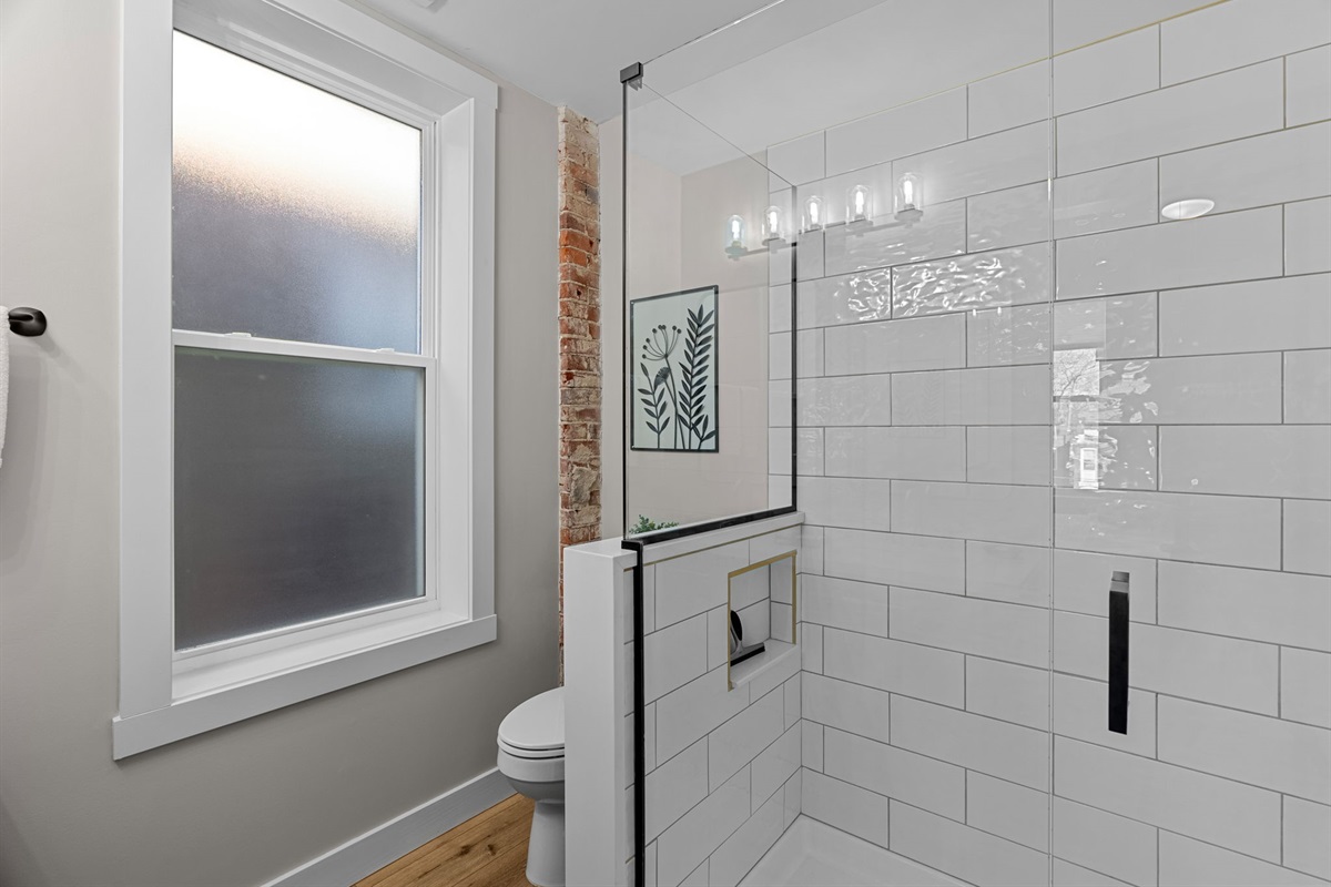 Spacious shower stocked with Shower gel, Shampoo, and Conditioner.
