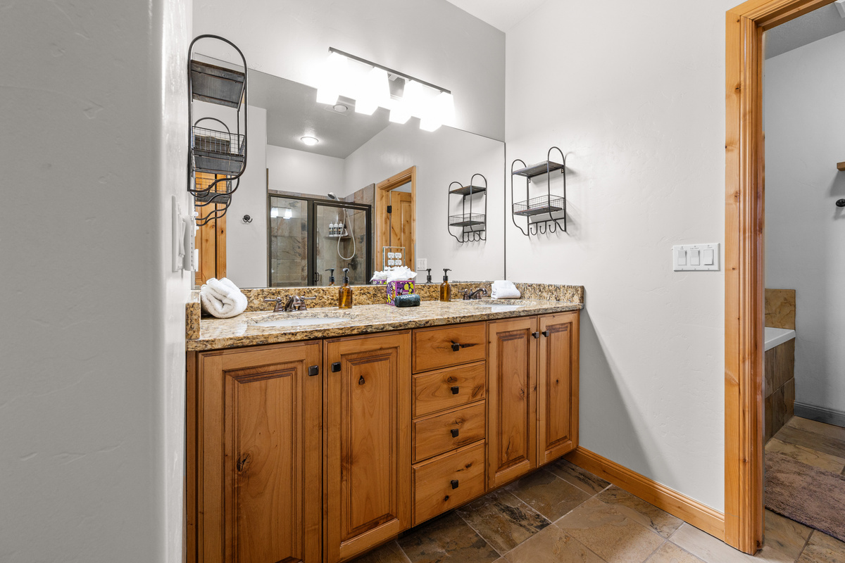 Primary bathroom with double vanity, jetted soaking tub, and separate shower.