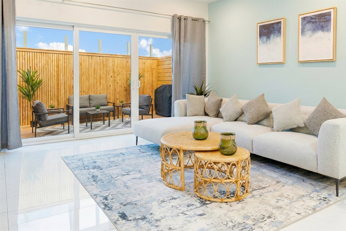 Open‑Concept Living Room with Plush Sofa, Coastal Décor & Sliding Glass Doors
