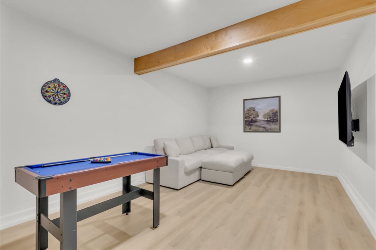 Dedicated game room with pool table, darts, TV, and lounge seating—perfect for movie nights, casual games, and relaxing in your own entertainment space.