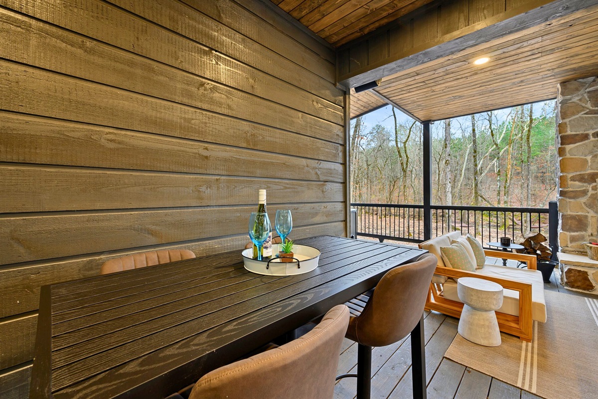 A stylish outdoor dining setup lets you enjoy snacks or drinks with a view of the trees.