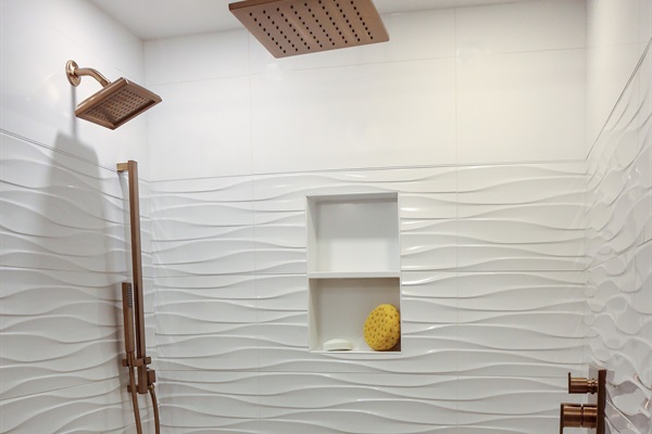 This bathroom features a rainfall shower head, a hand shower, and a standard shower head for an ultimate spa like experience 