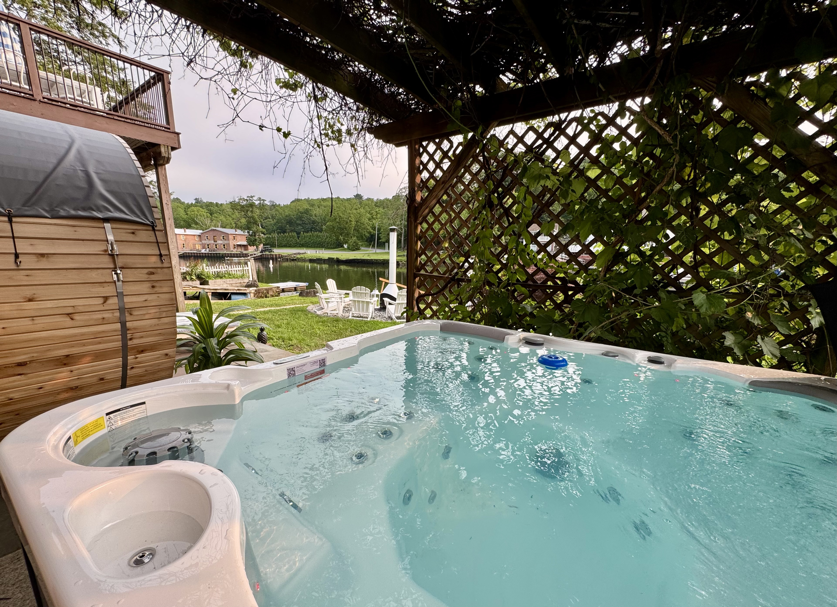 River Spa Patio — Soak in the hot tub while overlooking the river, cedar sauna, and waterfront fire pit.