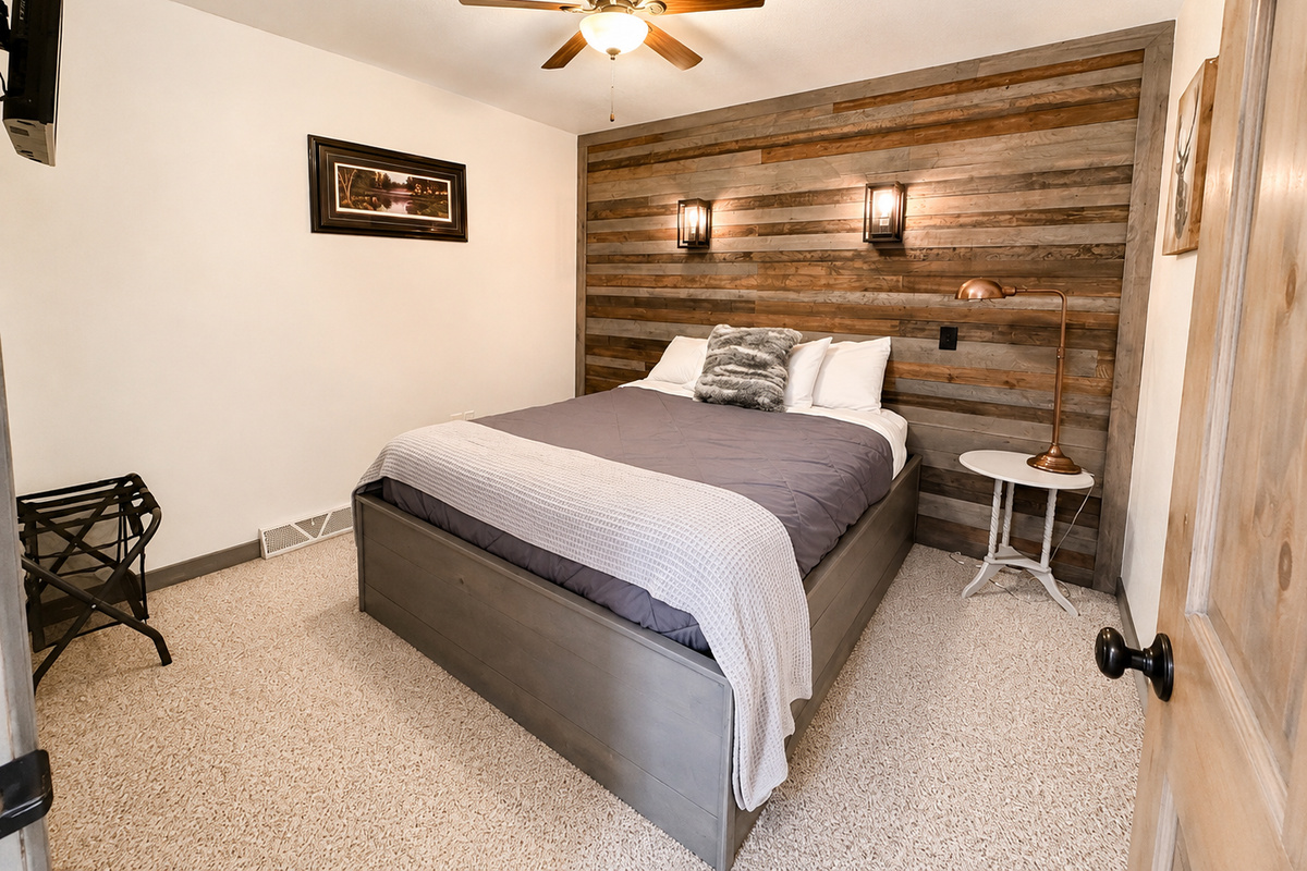 Cozy private Queen bed bedroom with rustic wood accents, comfortable furnishings, and a peaceful atmosphere for resting after a day of ATV riding, snowmobiling, hiking, or exploring Birchwood.