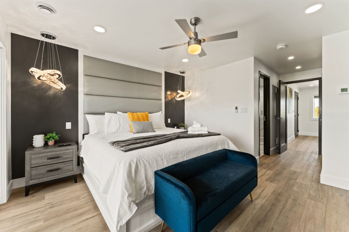 Master bedroom with king bed and Floor-to-ceiling windows framing the city skyline