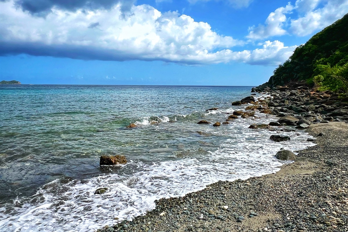 Pebble shoreline with crystal-clear waters to wade in.